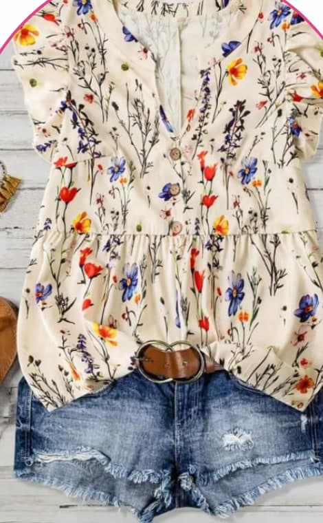 Cream blouse with a colourful wildflower print on a hanger