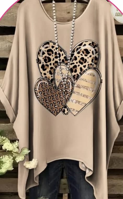 Model wearing a beige oversized batwing top with a leopard-print heart design