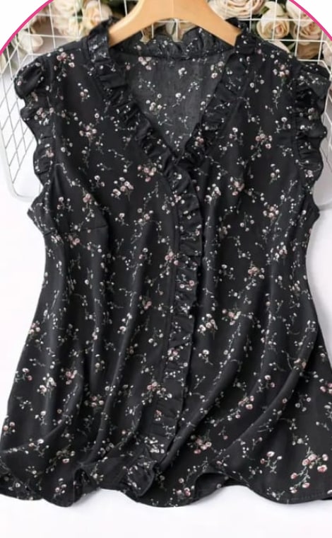 Black sleeveless blouse with a small floral print and ruffle trim on a hanger