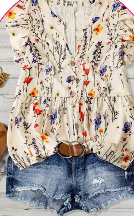 Cream blouse with a colourful wildflower print on a hanger